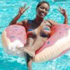 black millennial woman in pool holding up peace sign