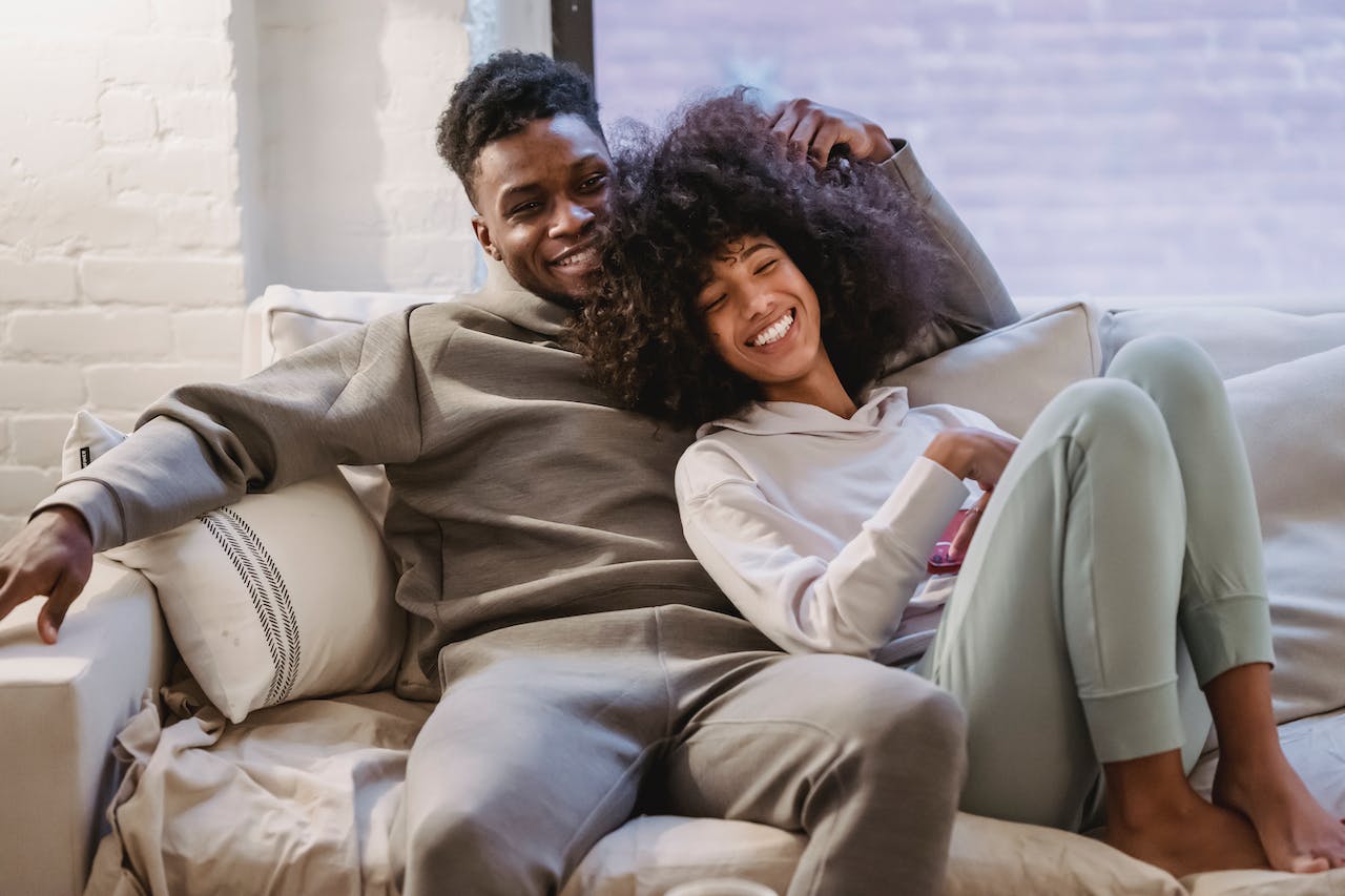 black couple laughing on couch on date night at home